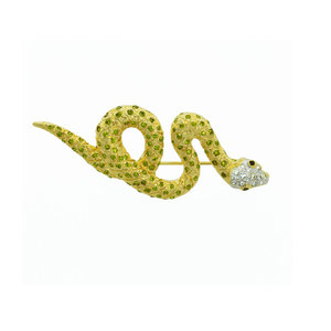 SWEET SNAKE - SWEET SNAKE is a sweet and elegant brooch, which embodyies snake's shape, an animal of grace, seduction and mystery.
This jewel is made of light gold with white and olivine crystals and black eyes. - A.Z. Bigiotterie